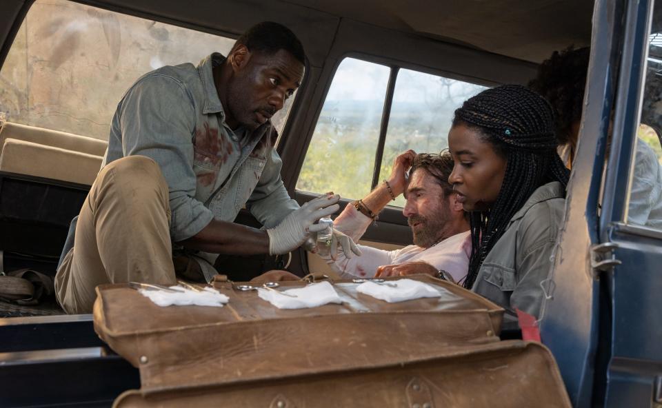 Nate (Idris Elba, left) tends to his injured friend Martin (Sharlto Copley) and addresses daughters Mare (Iyana Halley) and Norah (Leah Jeffries) after a lion attack in "Beast."