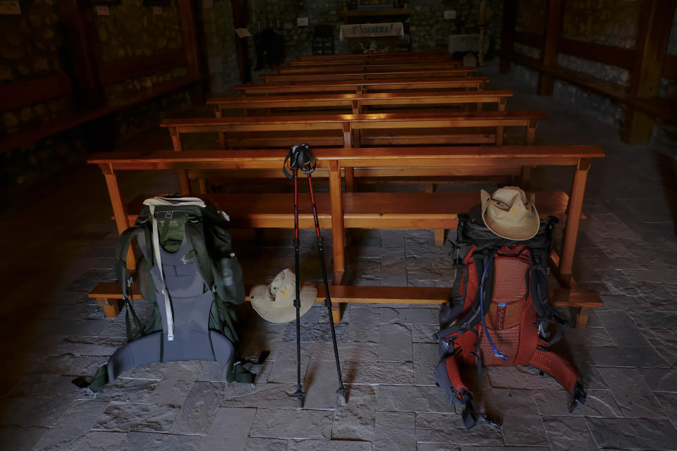 Pilgrims' backpacks photographed inside of a small church during a stage of "Camino de Santiago" or St. James Way in Rabe de Las Calzadas northern Spain, Wednesday, June 1, 2022. Over centuries, villages with magnificent artwork were built along the Camino de Santiago, a 500-mile pilgrimage route crossing Spain. Today, Camino travelers are saving those towns from disappearing, rescuing the economy and vitality of hamlets that were steadily losing jobs and population. “The Camino is life,” say villagers along the route. (AP Photo/Alvaro Barrientos)