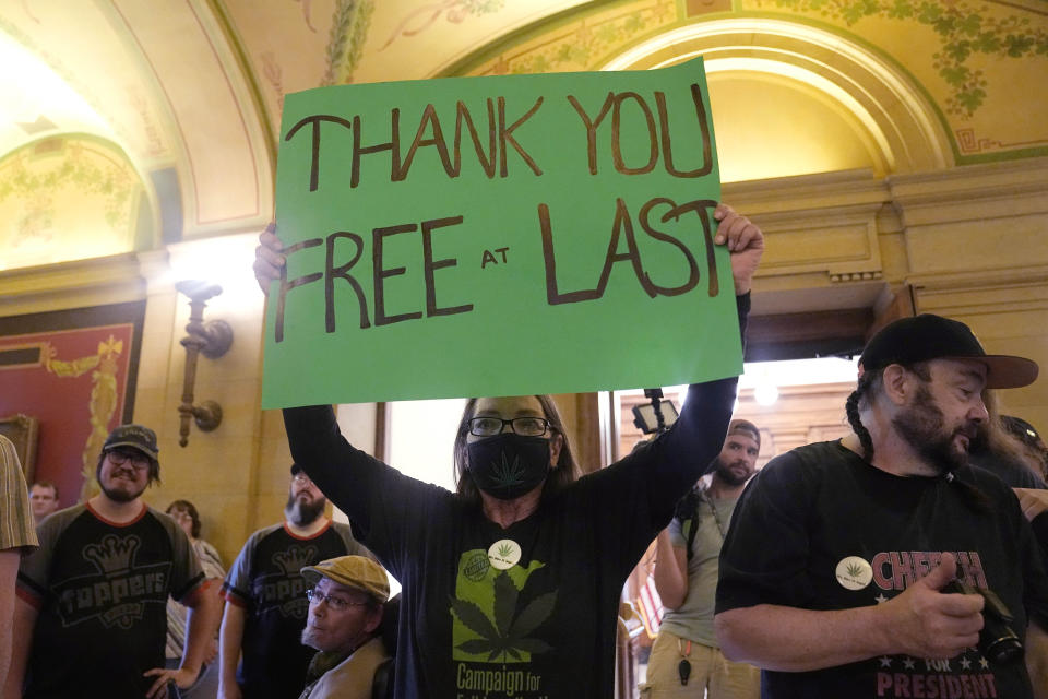 FILE - Amita Wolfe holds a sign supporting the legalization of marijuana, May 30, 2023, in St. Paul, Minn. Minnesotans can legally possess and grow their own marijuana for recreational purposes starting Tuesday, Aug. 1, subject to limits meant to keep a lid on things while the state sets up a full-blown legal cannabis industry. (AP Photo/Abbie Parr, file)