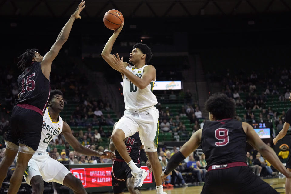 Baylor guard RayJ Dennis shoots against Nicholls State forward Jamal West Jr. as Michael Gray Jr. (9) and Baylor center Yves Missi look on during the first half of an NCAA college basketball game in Waco, Texas, Tuesday, Nov. 28, 2023. (AP Photo/LM Otero)