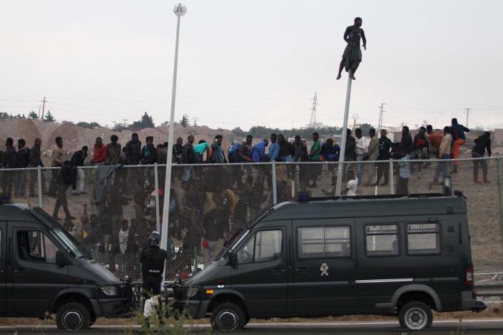 Sub-Saharan migrants sit on top of a metallic fence that divides Morocco and the Spanish enclave of Melilla, Thursday, May 1, 2014. Spain says around 700 African migrants have rushed its barbed wire border fences in the North African enclave of Melilla, and although police repelled most, 140 managed to enter Spanish territory. The migrants charged the fences in two waves, with 500 arriving in the early hours and another 200 later Thursday morning. Spain and Morocco stepped up border vigilance in Feb. when 15 migrants drowned trying to enter Spain's other north African coastal enclave, Ceuta. (AP Photo/Fernando Garcia)