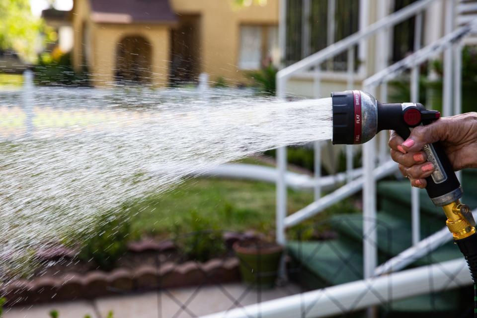 Pauline Garza, 91, uses a hose and shut-off nozzle to water her lawn on Thursday, July 13, 2023, in Corpus Christi, Texas. The activity is permitted anytime during current Stage 1 drought restrictions, according to the City.