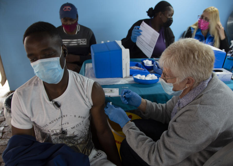 A man gets vaccinated against COVID-19 at a site near Johannesburg, Wednesday, Dec. 8, 2021. Omicron cases have been confirmed in at least nine African countries, with South Africa remaining the epicenter, with officials reporting that initial cases appear to be mild.(AP Photo/Denis Farrell)