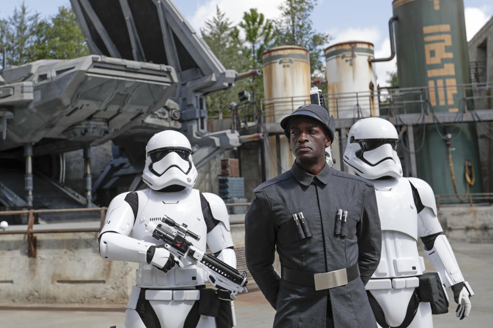 A First Order officer, center, and two storm troopers on patrol during a preview of the Star Wars themed land, Galaxy's Edge in Hollywood Studios at Disney World, Tuesday, Aug. 27, 2019, in Lake Buena Vista, Fla. The attraction will open Thursday to park guests. (AP Photo/John Raoux)