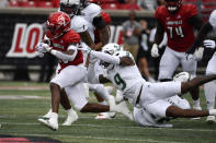 Louisville running back Jawhar Jordan (25) runs from the grasp of South Florida defensive back Aamaris Brown (9) during the first half of an NCAA college football game in Louisville, Ky., Saturday, Sept. 24, 2022. (AP Photo/Timothy D. Easley)