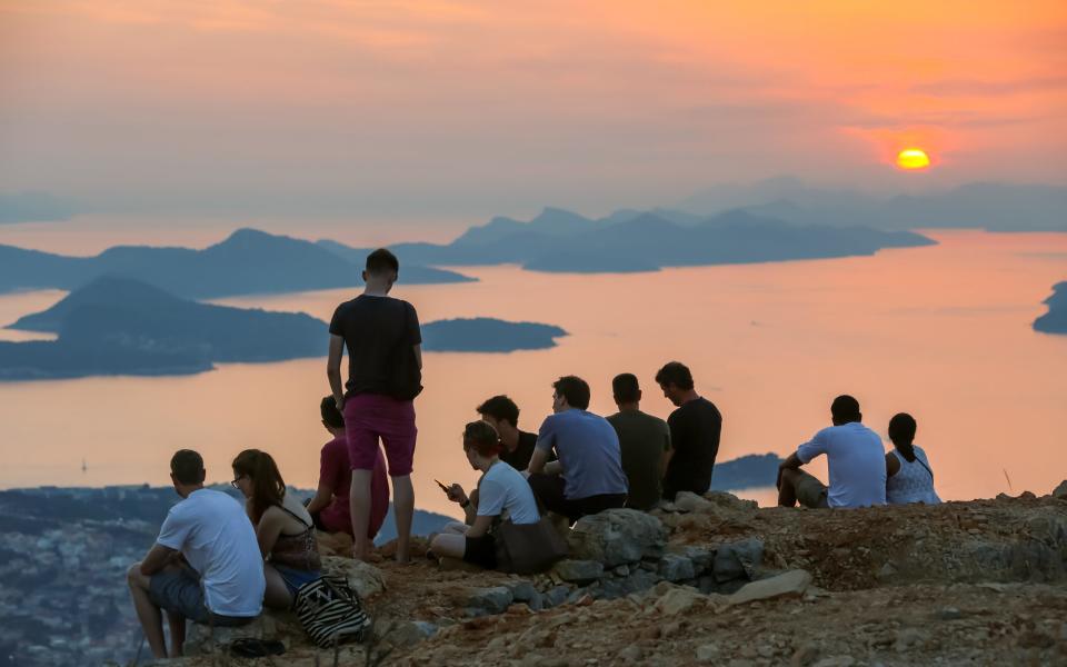 Tourists watch the sun set over the Elafiti islands - Getty
