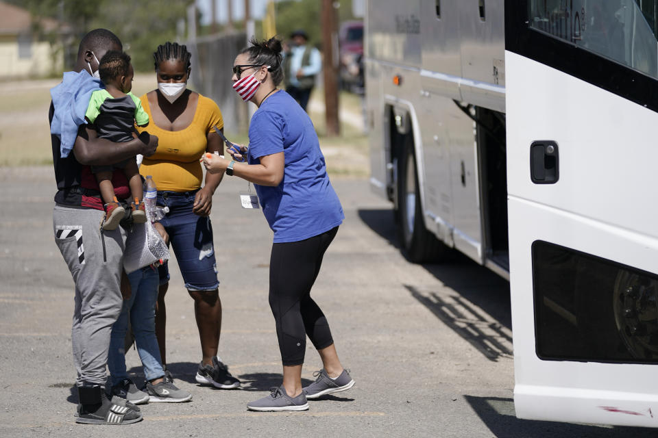 Migrants check in with a volunteer before boarding a bus to Houston at a humanitarian center after they were released from United States Border Patrol upon crossing the Rio Grande and turning themselves in seeking asylum, Wednesday, Sept. 22, 2021, in Del Rio, Texas. (AP Photo/Julio Cortez)
