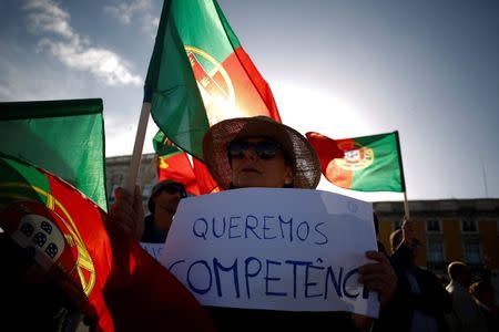 A woman holds a paper saying "we want competence" during a demonstration in a tribute to the victims of the deadly fires in Portugal, in Praca do Comercio square, downtown Lisbon, Portugal October 21, 2017. REUTERS/Pedro Nunes