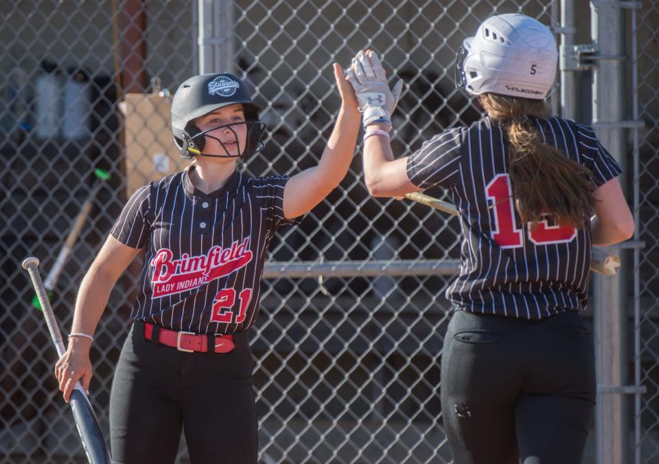 Brimfield’s Kylee Vaughn (21) high-fives teammate Hayley Wallace after Wallace scored against Illini Bluffs in the seventh inning Wednesday, May 5, 2021 at Brimfield High School. Illini Bluffs defeated the Indians 8-3.