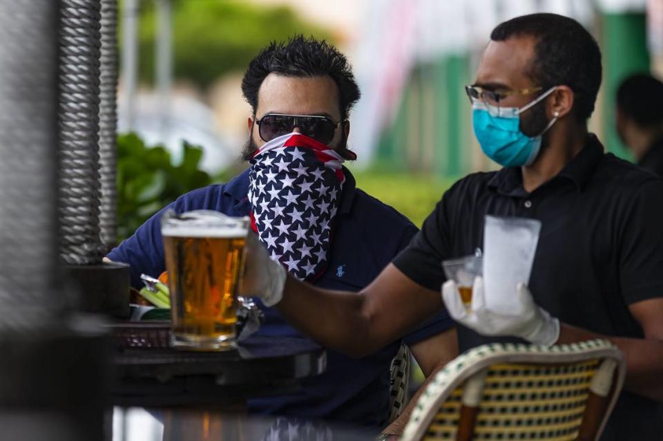 Chris Winokur, 39, orders a beer at FlaniganÕs in Kendall on the first day Miami-Dade County allowed restaurants to reopen their dining rooms on Monday, May 18, 2020. In order to control the spread of the coronavirus, Miami officials prohibited restaurants from operating their dining rooms on March 16, 2020.