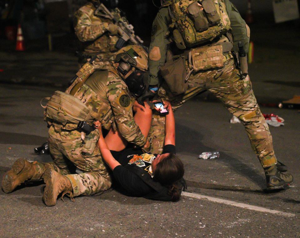 Federal agents detain a woman early on July 27, 2020, outside of the federal courthouse in Portland, Oregon, during a protest.