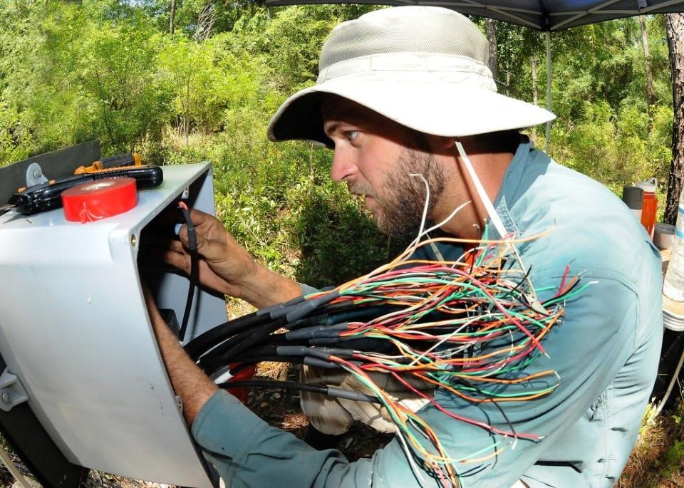 Kenyon Watkins, senior field technician for Dr. Matt Cohen, sets up sensors to gather data on how different land management approaches affect springs.