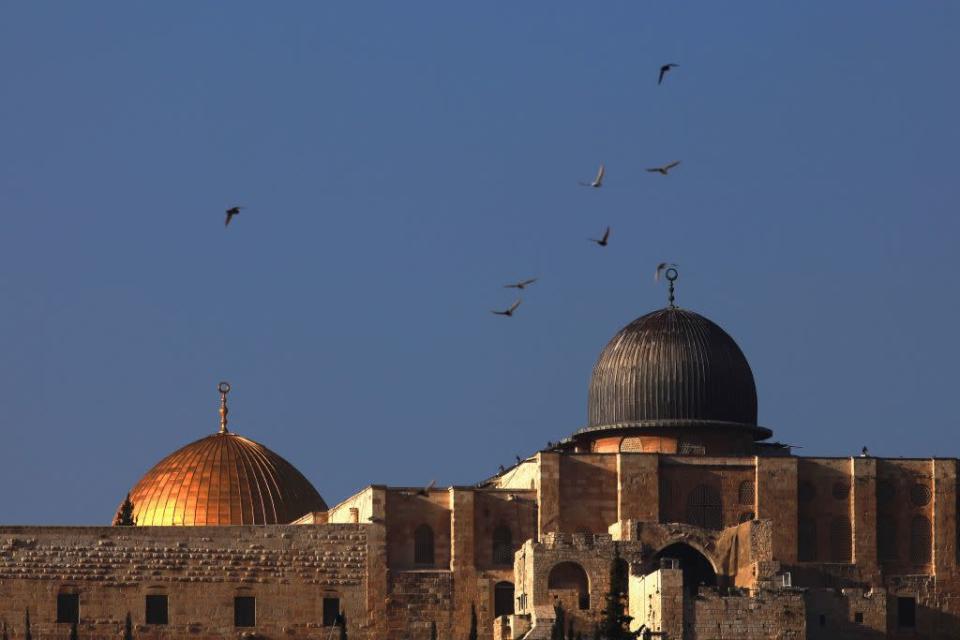 <b>JERUSALEM, ISRAEL:</b> Birds fly over al-Aqsa mosque and the golden Dome of the Rock Islamic shrine as seen from the East Jerusalem neighborhood of Silwan.