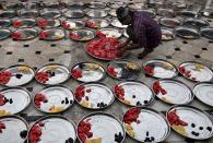 <p>Ein Muslim im indischen Ahmedabad bereitet in einer Moschee anlässlich des Ramadan Teller mit Essen für das Fastenbrechen vor. (Bild: REUTERS/Amit Dave) </p>