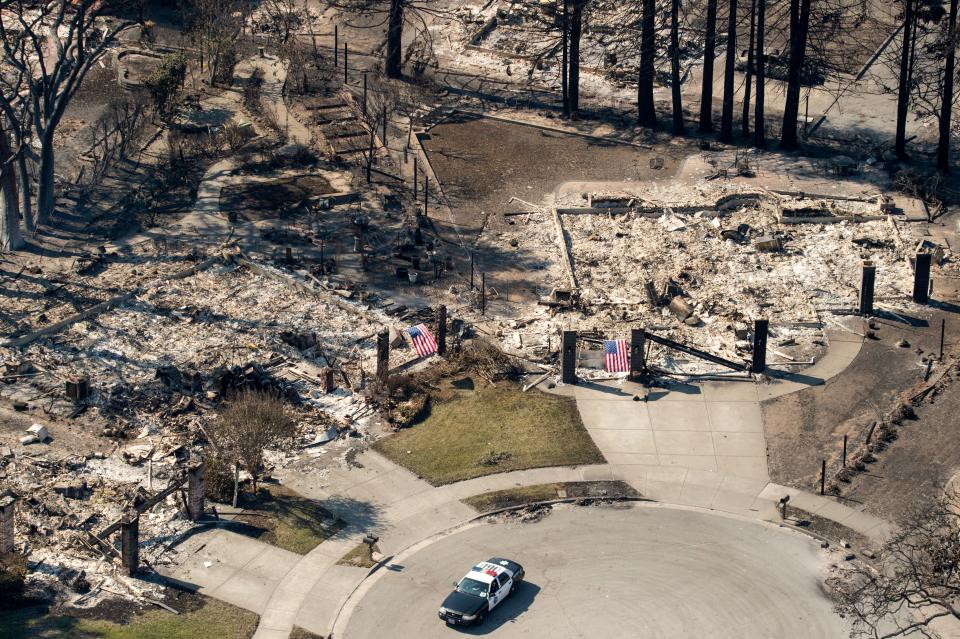 <p>In this aerial view, a police officer drives near burned properties in Santa Rosa, Calif., on Oct. 12, 2017. (Photo: Josh Edelson/AFP/Getty Images) </p>