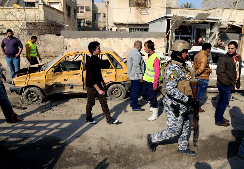 Civilians and security forces gather at the site of a car bomb attack near the Technology University in Sinaa Street in downtown Baghdad, Iraq, Wednesday, Jan. 15, 2014. A wave of bombings across Iraq striking busy markets and a funeral north of Baghdad killed tens of people Wednesday, authorities said, as the country remains gripped by violence after al-Qaida-linked militants took control of two cities in western Anbar province. (AP Photo/Karim Kadim)