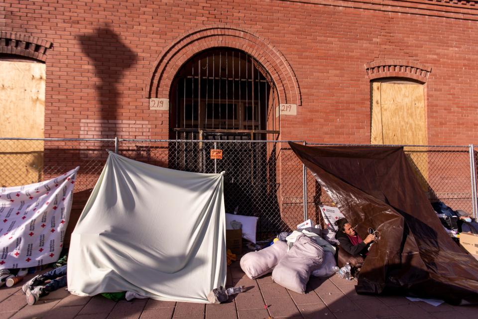 Migrants build tents with blankets donated to stay warm on the streets of El Paso, Texas, on Saturday, Dec. 17, 2022, after being released after crossing into the U.S.