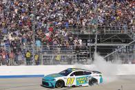 Denny Hamlin celebrates with a burnout after winning a NASCAR Cup Series auto race at Dover Motor Speedway, Sunday, April 28, 2024, in Dover, Del. (AP Photo/Derik Hamilton)