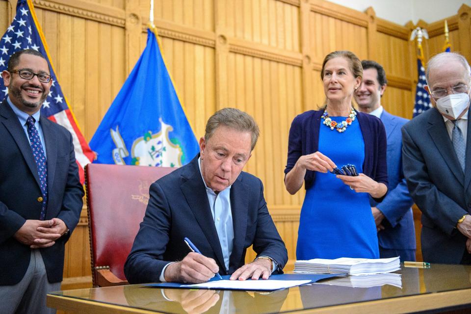 Connecticut Gov. Ned Lamont signs a law in June 2021 in Hartford, Connecticut.