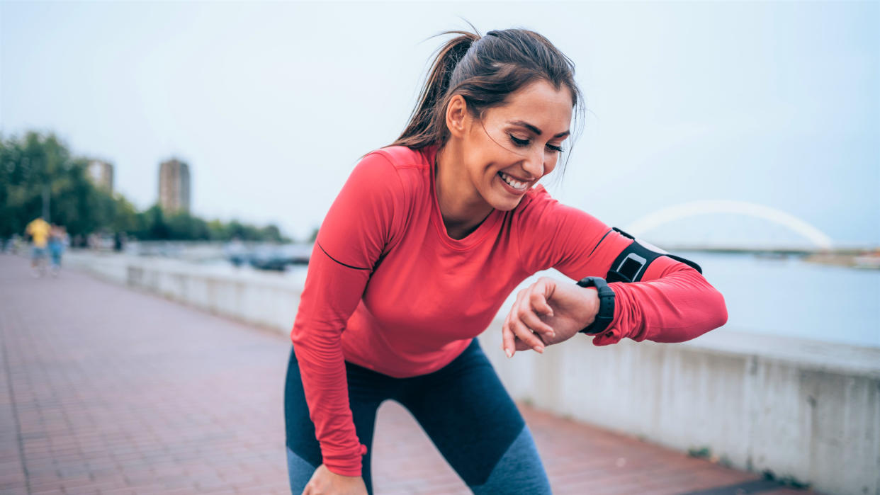  Woman checking GPS watch during run 