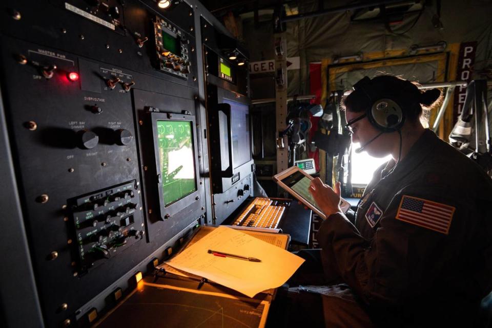 Maj. Sonia Walker, aerial reconnaissance weather officer with the U.S. Air Force Reserve 53rd Weather Reconnaissance Squadron “Hurricane Hunters,” works aboard the C-130 Super Hercules aircraft Tuesday, Jan. 28, 2020, somewhere over the Pacific Ocean. She said it’s her job to quality check data from sensors on the aircraft and from the dropsondes, which are dropped from the air.