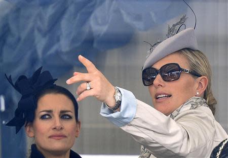 Britain's Zara Phillips (R) speaks with an unidentified friend as she attends the Cheltenham Festival horse racing meet in Gloucestershire, western England March 14, 2014. REUTERS/Toby Melville