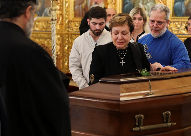 A woman pays her respects next to the coffin of the late Archbishop Chrysostomos II at the Apostle Varnavas Cathedral in Nicosia