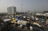 Indian farmers sit on their tractors after arriving at the Delhi-Uttar Pradesh border for Tuesday's tractor rally in New Delhi, India, Monday, Jan. 25, 2021. Thousands of farmers gathered on the borders of Delhi for a massive tractor rally on Tuesday against the three contentious farm laws when India will celebrate its Republic day with a military and cultural parade. The two-month-old old blockade of highways connecting the capital with the country's north continues as the talks have remained deadlocked with the government refusing to scrap the new agricultural reform laws which the farmers say will benefit large corporations. (AP Photo/Manish Swarup)