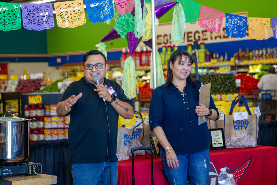 Christian "Ruffian" Martinez (left), on-air personality and producer for Tricolor 103.5, announces the winners along with Susy Ferry (right), public relations manager of Basha's, on Nov. 12, 2023, in Phoenix.