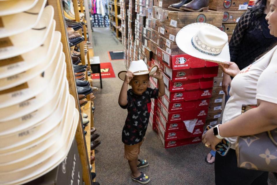 Eli Jr., 3, shops with his mother Candy Segovia at El Alazan Western Wear in Cardinal Valley off Alexandria Drive in Lexington.