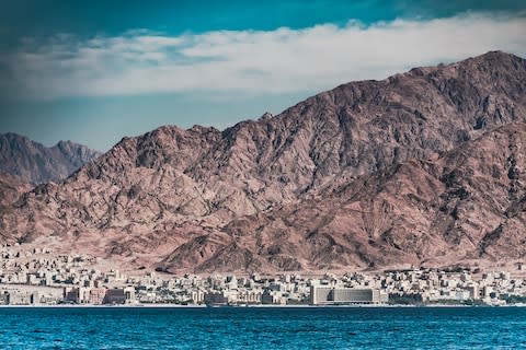 Mountains tower over the Red Sea city of Aqaba - Credit: getty