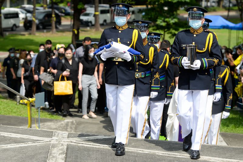 A military honour guard carries the urn of former Philippine President Benigno Aquino in Quezon City