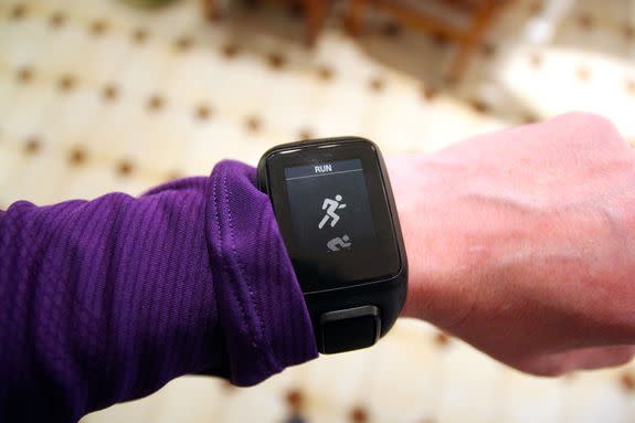 A jogger checks her GPS fitness tracking watch before going for a run.