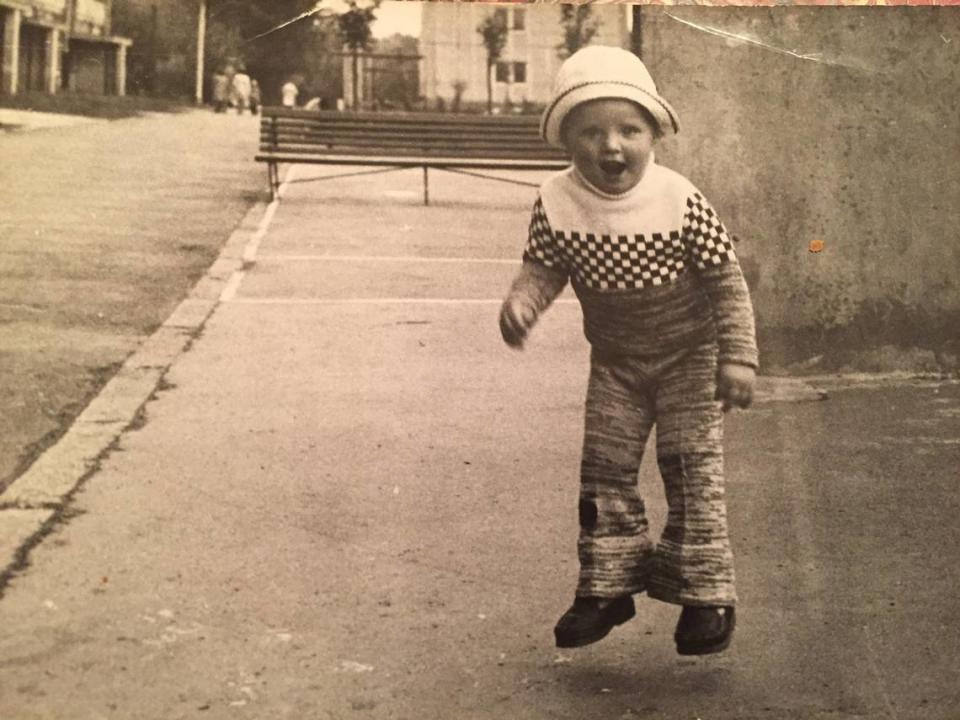 Max Savar at around 3 or 4 years old, photographed in front of the apartment building where his family was living at the time in Warsaw, Poland. He recalls the building as “classic communist-era architecture of thousands small apartments in the forest of identical tall and long buildings. Two small rooms and a kitchen — no living room — was considered a luxury of those days. And you were very lucky to have it.”