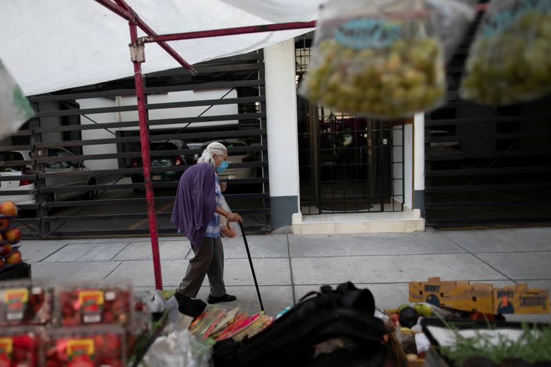 A woman walks at the local street market after Mexico's government declared a health emergency on Monday and issued stricter rules aimed at containing the fast-spreading coronavirus disease (COVID-19), in Mexico City