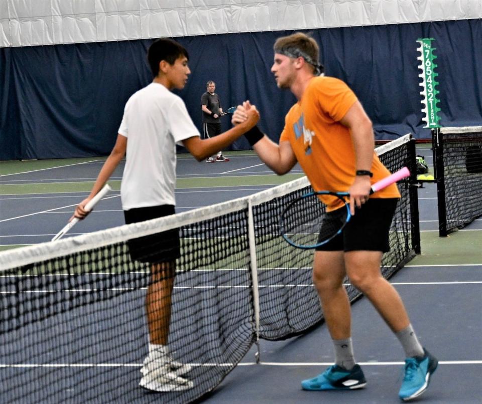 Ethan Remy and Justin Csepe shake hands at the net after their men's singles title match in the 90th News Journal Tennis Tournament.