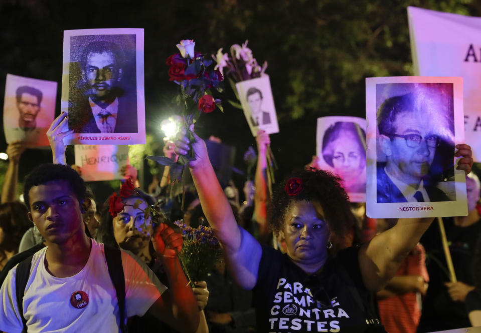 Demonstrators hold photos of persons who were killed during Brazil's dictatorship during a protest in Sao Paulo, Brazil, Sunday, March 31, 2019. Over the objections of human rights groups, but with the support of far-right President Jair Bolsonaro, some military bases are commemorating the March 31, 1964, coup that lasted two decades in Brazil and made for thousands of victims. (AP Photo/Andre Penner)