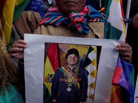 FILE PHOTO: A supporter holds a poster of Bolivia's President Evo Morales during the registration of candidates in Bolivian primaries, in La Paz, Bolivia, November 28, 2018. REUTERS/David Mercado/File Photo