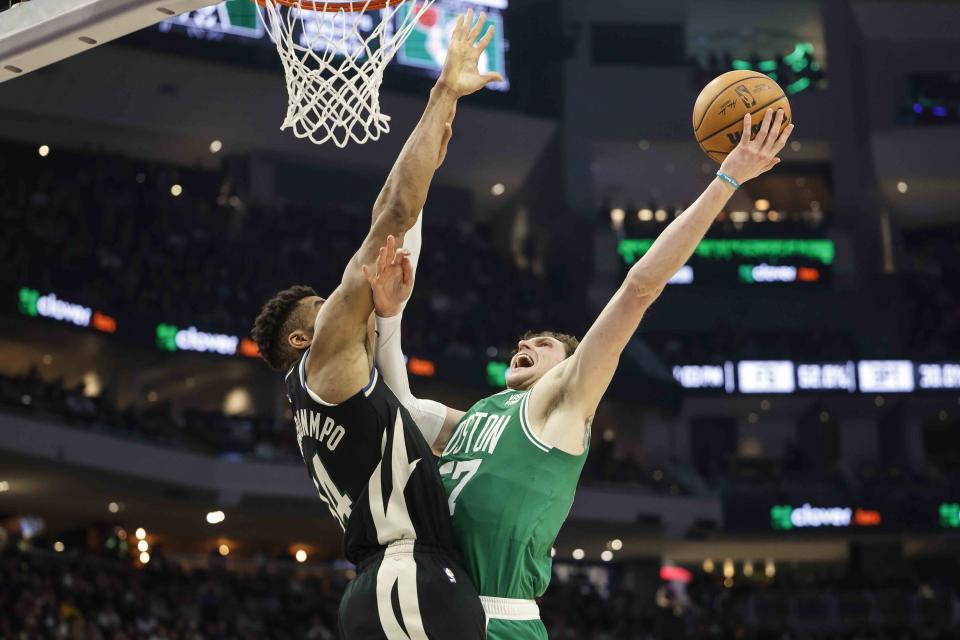 Boston Celtics' Mike Muscala, right drives against Milwaukee Bucks forward Giannis Antetokounmpo during an NBA basketball game, Tuesday, Feb. 14, 2023, in Milwaukee. (AP Photo/Jeffrey Phelps)