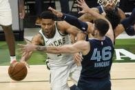 Milwaukee Bucks' Giannis Antetokounmpo passes around Memphis Grizzlies' John Konchar during the first half of an NBA basketball game Saturday, April 17, 2021, in Milwaukee. (AP Photo/Morry Gash)