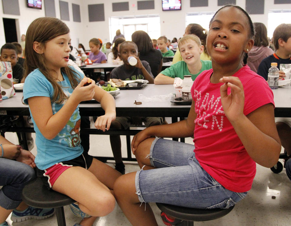 Eastside Elementary school fourth grader Raela Bridges, nine, right, explains what parts of the school lunch she likes to her classmates Grace Bethany, left, Cameron Kinard, back left, and Brock Maddox, back right, all nine, Wednesday, Sept. 12, 2012 in Clinton, Miss. While much consideration goes into the planning of these school children's lunches, the children have their own strong opinions about what items they prefer to eat. (AP Photo/Rogelio V. Solis)