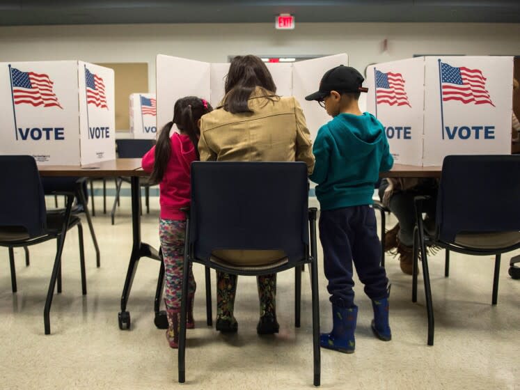 A woman and her children vote at a polling station.