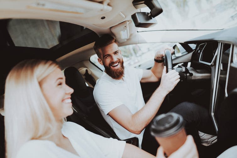 A man behind the wheel of a Tesla.