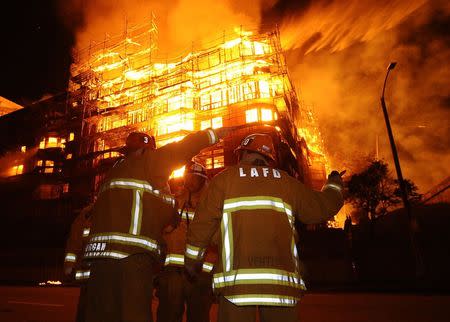 Los Angeles city firefighters battle a massive fire at a seven-story downtown apartment complex under construction in Los Angeles, California December 8, 2014. REUTERS/Gene Blevins