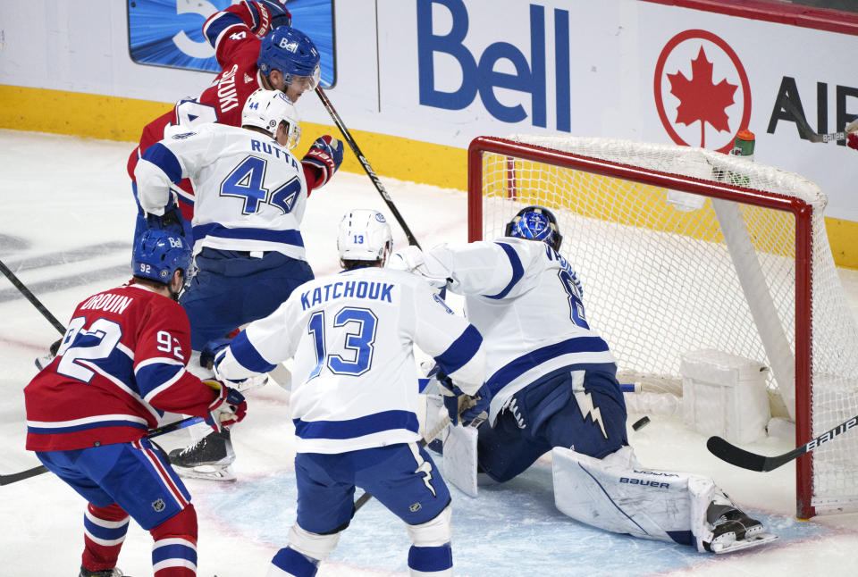 Montreal Canadiens' Nick Suzuki, top, scores past Tampa Bay Lightning goaltender Andrei Vasilevskiy during the second period of an NHL hockey game Tuesday, Dec. 7, 2021, in Montreal. (Paul Chiasson/The Canadian Press via AP)