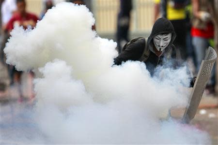 An anti-government protester throws a gas canister back at the police during a protest against President Nicolas Maduro's government in Caracas April 17, 2014. REUTERS/Carlos Garcia Rawlins