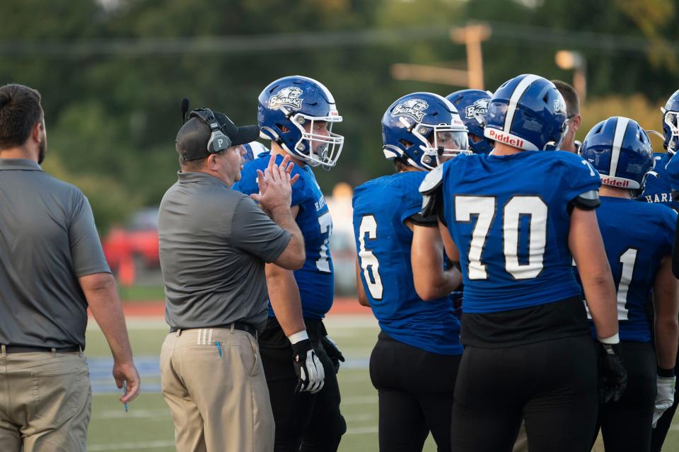 Harper Creek head coach Mason Converse talks with players during a game against Marshall at Harper Creek High School on Friday, Sept. 15, 2023.