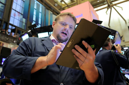 FILE PHOTO: A trader works on the floor at the New York Stock Exchange (NYSE) in New York, U.S., April 18, 2019. REUTERS/Brendan McDermid