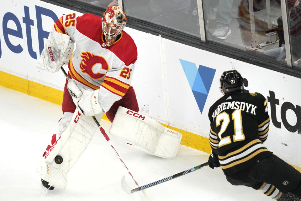 Calgary Flames goaltender Jacob Markstrom (25) fails to clear the puck while pressured by Boston Bruins left wing James van Riemsdyk (21) during the first period of an NHL hockey game, Tuesday, Feb. 6, 2024, in Boston. (AP Photo/Charles Krupa)