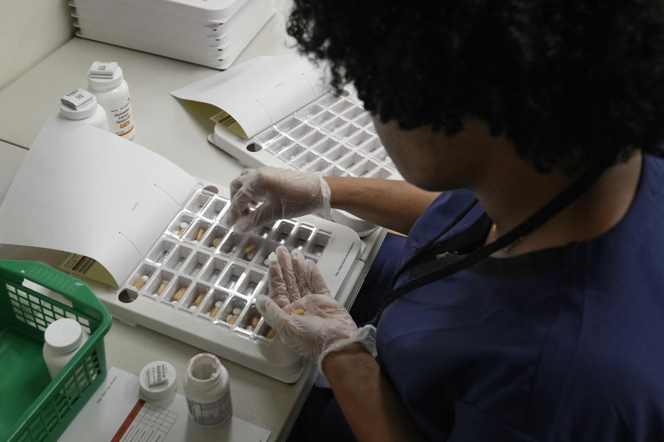 Lachandretta "LaLa" Williams fills a monthly medication blister pack at MAC Pharmacy, Wednesday, May 29, 2024, in Cleveland. (AP Photo/Sue Ogrocki)